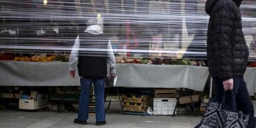 La Paris în pieţe şi pe stradă oamenii se protejează de coronavirus cu plastic FOTO EPA-EFE / Julien de Rosa