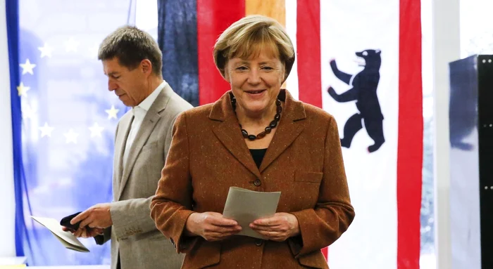 Angela Merkel şi soţul ei, Joachim Sauer (plan secund), la o secţie de votare din Berlin, pe 22 septembrie, cu ocazia alegerilor legislative FOTO Reuters