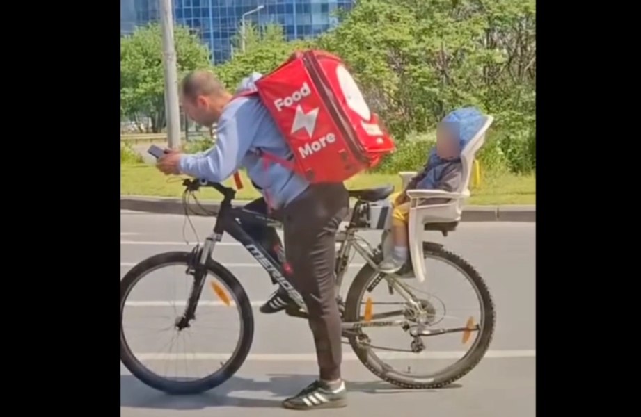 Imagini virale cu un livrator Tazz: filmat cu copilul adormit pe bicicletă
