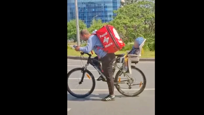 Un bărbat îți ia copilul cu el la muncă, pe bicicletă FOTO: Captura video