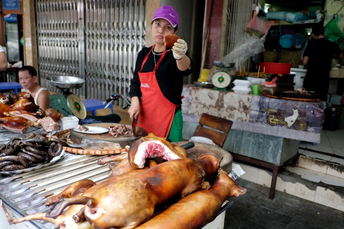 Vietnameza vinde carne de câine pe o stradă din Vietnam. FOTO: EPA EFE