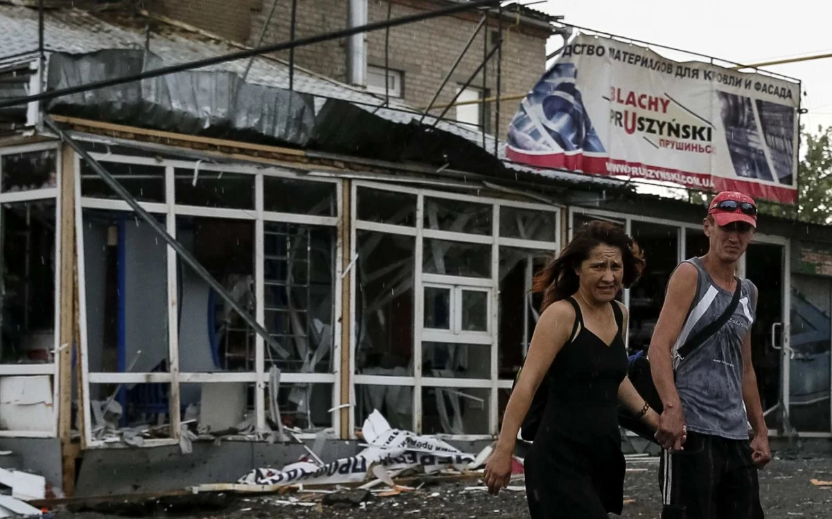 Localnici din Slaviansk, oraş situat în estul Ucrainei, trecând pe lângă dărâmăturile mai multor localuri, distruse în timpul confruntărilor dintre  forţele ucrainene şi separatiştii FOTO Reuters/10 iunie