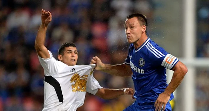 Terry (dreapta), într-un duel cu un jucător din campionatul intern din Thailanda. FOTO: Chelsea.com