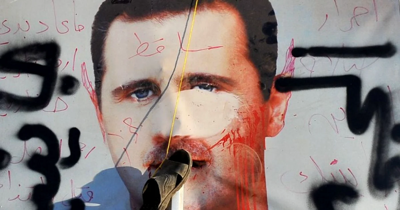 Un afiş vandalizat cu preşedintele sirian Bashar Al-Assad FOTO AFP
