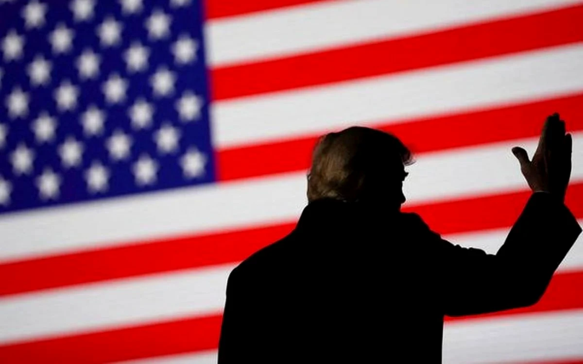 Trump salutând pe fondul steagului SUA