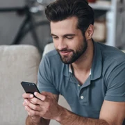 Barbat  tanar cu un telefon smartphone in mana FOTO Shutterstock 