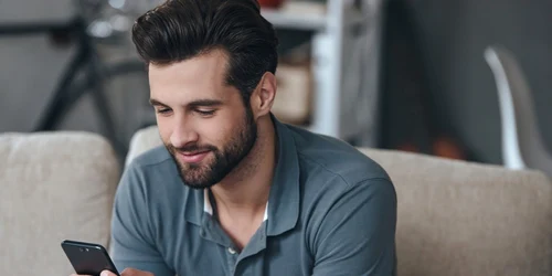 Barbat tanar cu un telefon smartphone in mana FOTO Shutterstock