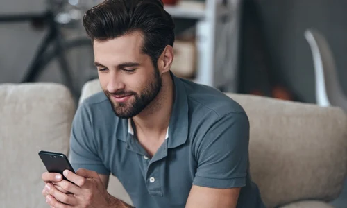 Barbat  tanar cu un telefon smartphone in mana FOTO Shutterstock 