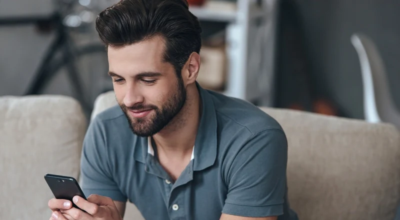 Barbat  tanar cu un telefon smartphone in mana FOTO Shutterstock 