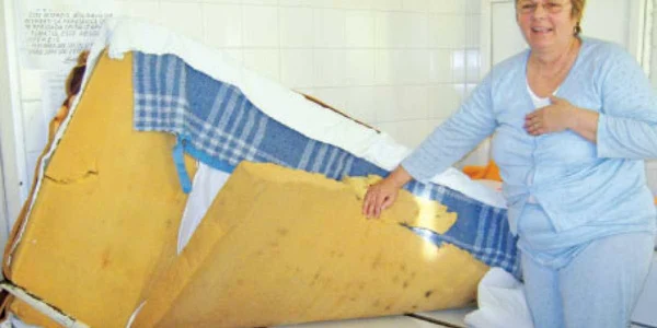 Elena Gagiu stă într-un pat a cărui saltea se sprijină pe bucăţi de rafturi 