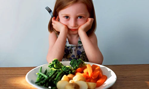getty rm photo of girl in front of plate of veggies jpeg