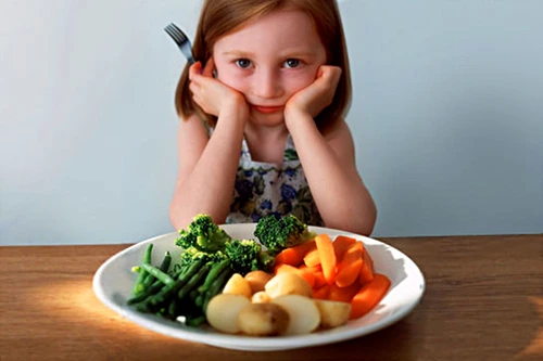 getty rm photo of girl in front of plate of veggies jpeg