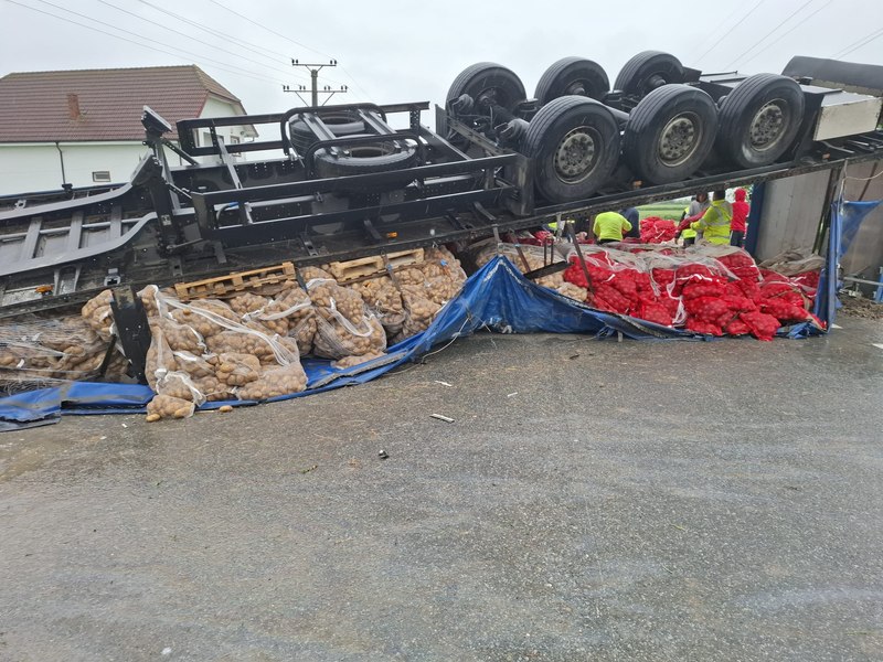 Imagini de la TIR-ul plin cu cartofi s-a răsturnat în urma coliziunii cu o mașină. Unul dintre şoferi a murit. Au fost impuse restricții de trafic