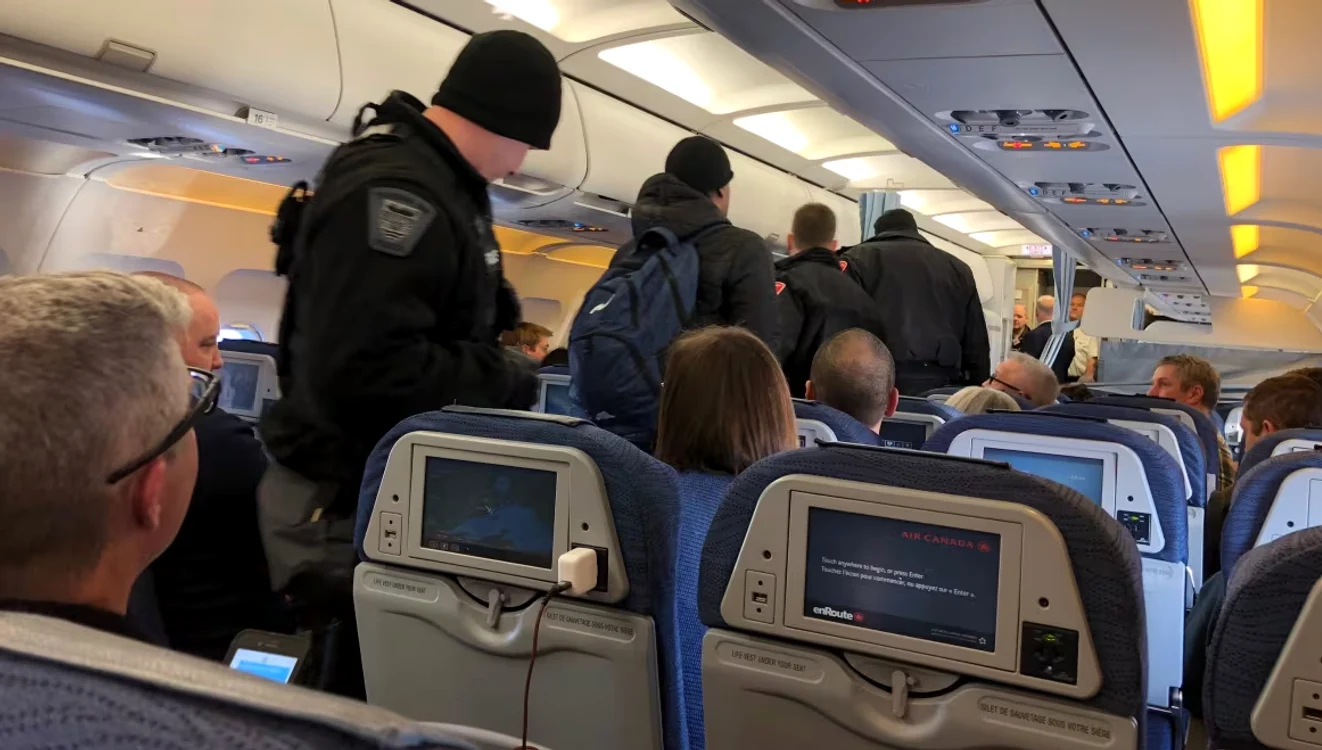 Pasager escortat de poliție. Sursa: CBC