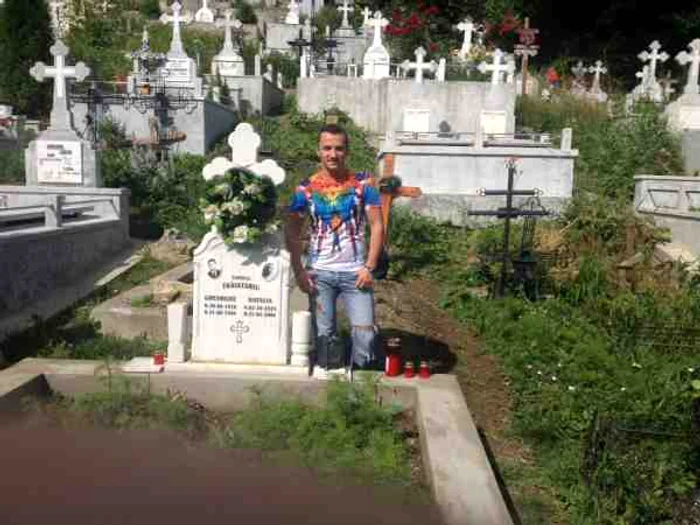 Mihai Trăistariu apare foarte zâmbăreț în fotografia făcută în cimitir, lângă mormântul părinților săi.