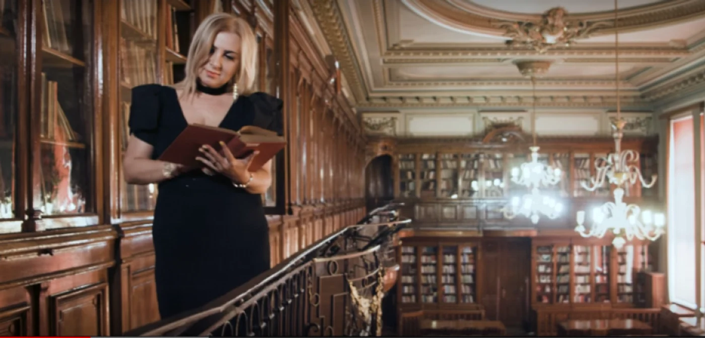 Carmen Şerban, răsfoind o carte groasă din biblioteca Universităţii de Medicină FOTO Captură Virgin Radio