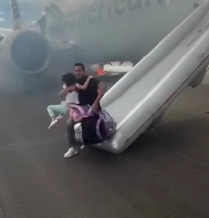 Acest bărbat a căzut pe pistă cu tot cu copil din cauza bagajului uriaș (Foto: captură video)