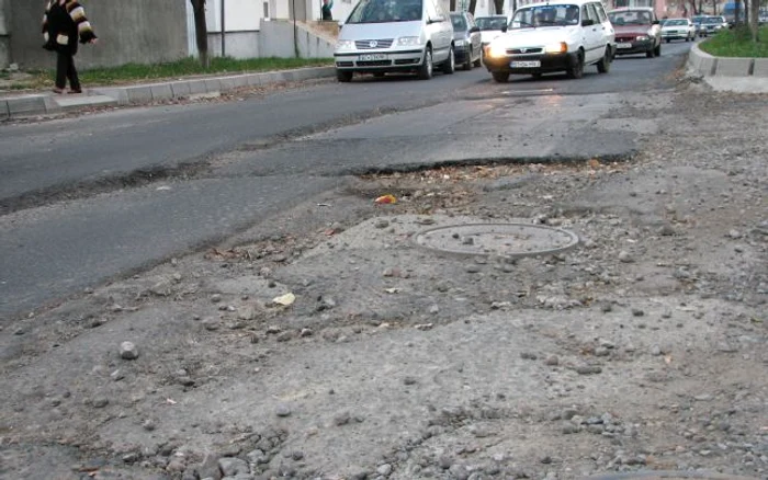 Şoferii şi pietonii trebuie să facă slalom printre gropi.