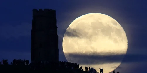 Luna plină se ridică în spatele Glastonbury Tor unde oamenii se adună pentru a sărbători solstiţiul de vară la în Somerset Anglia FOTO Guliver/ Getty Images/ Matt Cardy