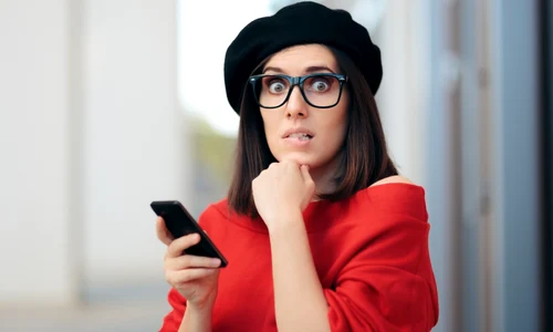 femeie surprinsa telefon ochelari foto shutterstock