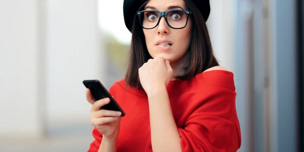 femeie surprinsa telefon ochelari foto shutterstock
