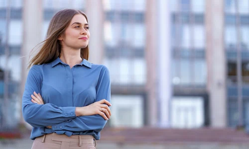 shot beautiful young businesswoman wearing blue chiffon shirt while standing building street with folded arms jpg