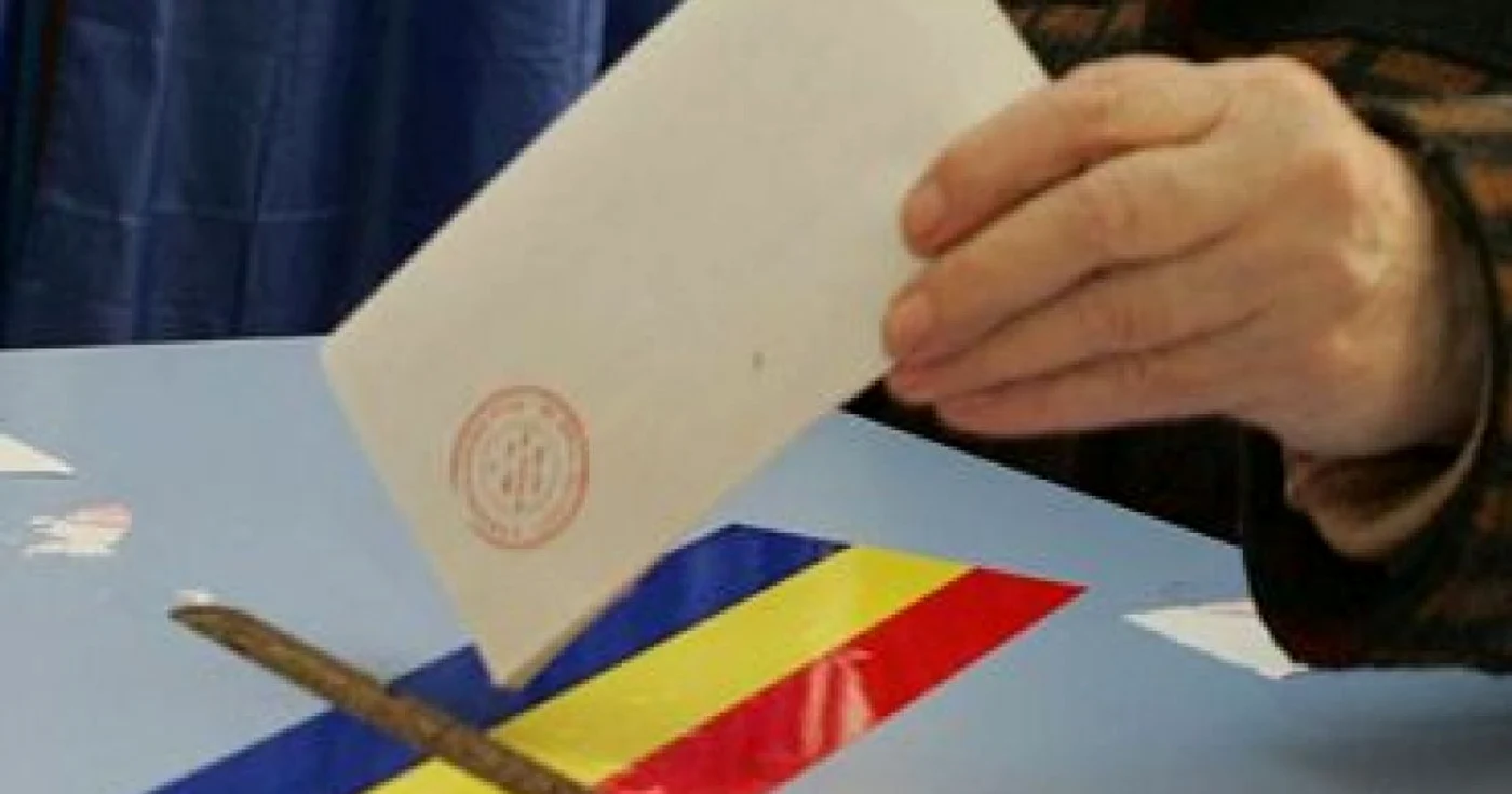 Cineva pune un buletin de vot în urnă