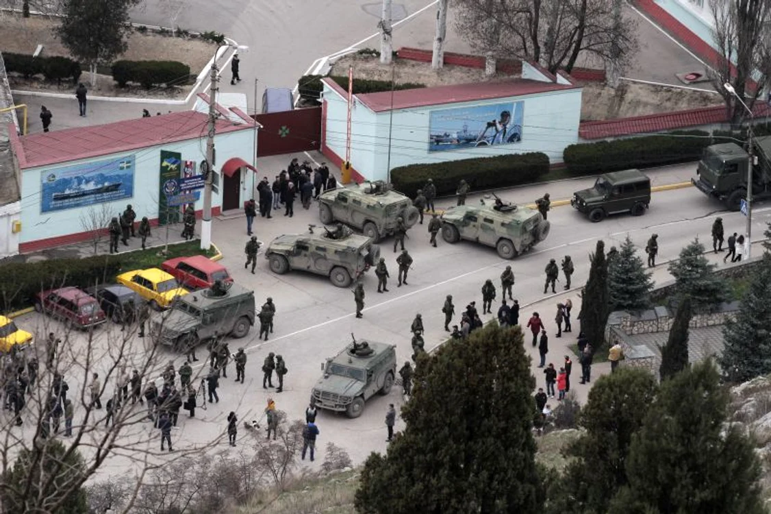 
    Militarii ruşi aşteaptă lângă vehiculele blindate, la graniţa cu Ucraina, în apropierea localităţii Balaclava. (Foto: Reuters)  