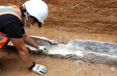 Un cercetător curăță sicriul de plumb din epoca romană descoperit în Colchester, Marea Britanie (© Colchester Archaeological Trust)