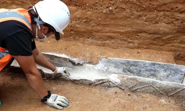Un cercetător curăță sicriul de plumb din epoca romană descoperit în Colchester, Marea Britanie (© Colchester Archaeological Trust)