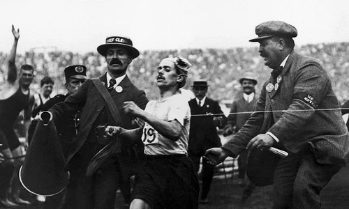 Maratonistul italian Dorando Pietri, ajutat să treacă linia de sosire la Olimpiada de la Londra din 1908 (© Wikimedia Commons)