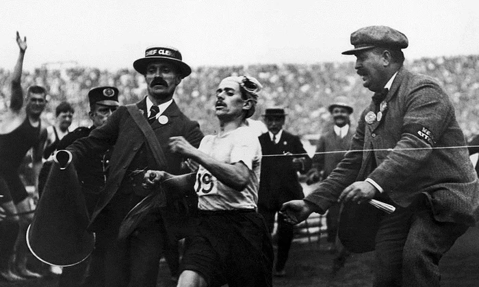 Maratonistul italian Dorando Pietri, ajutat să treacă linia de sosire la Olimpiada de la Londra din 1908 (© Wikimedia Commons)