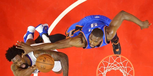 DeAndre Jordan (S) de la Los Angeles Clippers aruncă la coş iar atacantul Serge Ibaka al echipei Oklahoma City Thunder încearcă să pareze în timpul unei partide din NBA desfăşurată la Los Angeles California FOTO AP