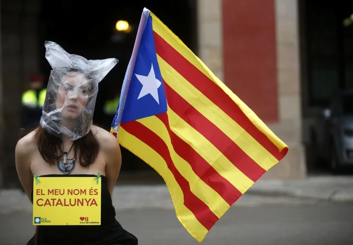 Un protestatar pro-independenţă stă în faţa parlamentului din 
Catalunia în timp ce parlamentarii voteaza în Barcelona, Spania   FOTO 
Reuters