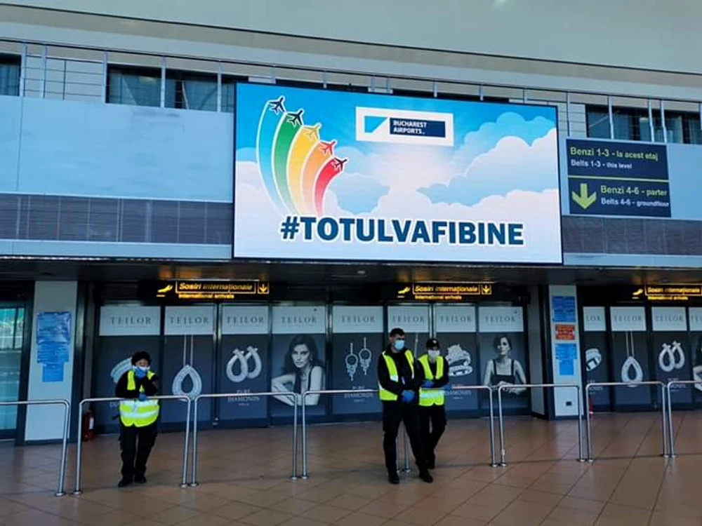 Pe tabelă apare din când în când mesajul ”Totul va fi bine”, în timp ce câțiva angajați așteaptă