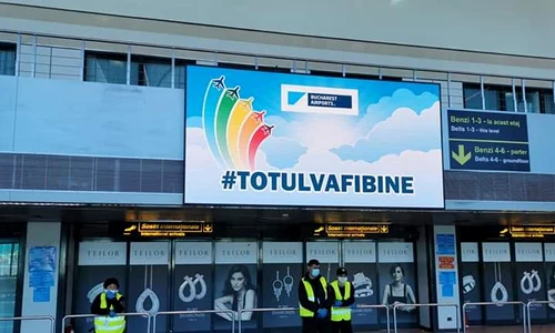 Pe tabelă apare din când în când mesajul ”Totul va fi bine”, în timp ce câțiva angajați așteaptă jpeg