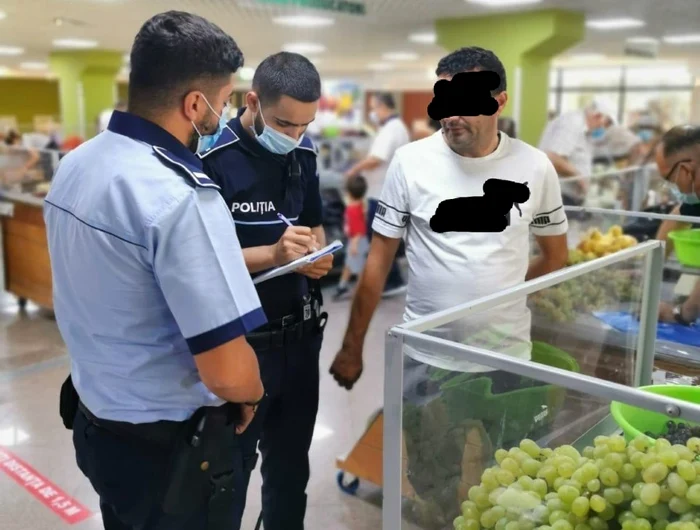 Bărbatul din imagine a fost amendat de polițiști pentru că nu purta mască în interiorul pieței