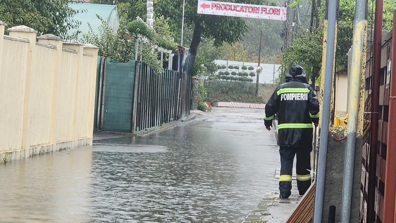 Un pompier merge prin apa până la glezne dintr-o localitate afectată de inundații
