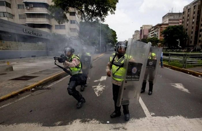 Scutieri tragând cu gloanţe de cauciuc în protestatarii din Caracas FOTO AFP