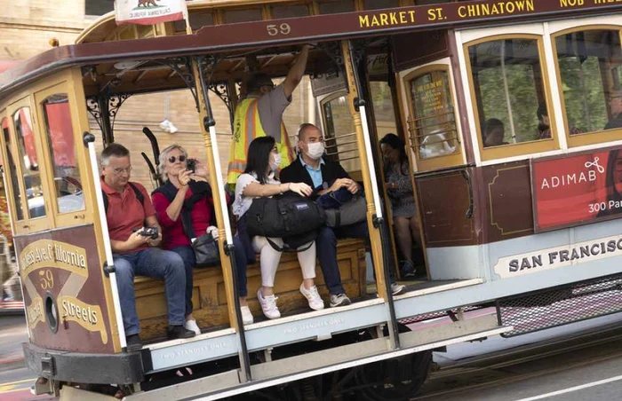 Turisti poarta masti de protectie in timp ce se plimbă prin Chinatown, în San Francisco - California FOTO EPA-EFE