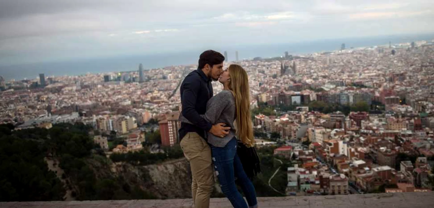 Un cuplu de turişti se sărută în timp ce vizitează un bunkăr anti-aerian pe fundal se vede oraşul Barcelona Spania FOTO Guliver/GettyImages
