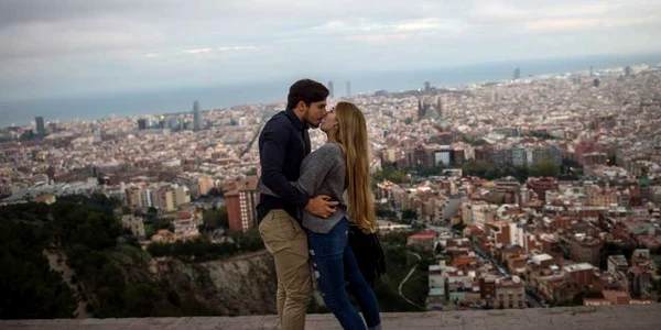 Un cuplu de turişti se sărută în timp ce vizitează un bunkăr anti-aerian pe fundal se vede oraşul Barcelona Spania FOTO Guliver/GettyImages