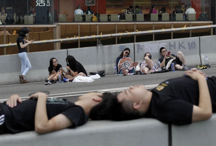 Protestatari pro-democraţie din Hong Kong, odihnindu-se la intrarea în complexul de clădiri guvernamentale în care îşi are sediul liderul executiv Leung FOTO AP