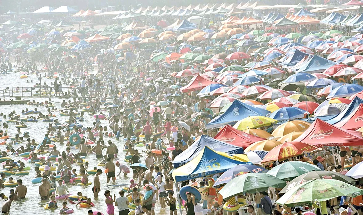 Pe plajă, umbrelă  lângă umbrelă
