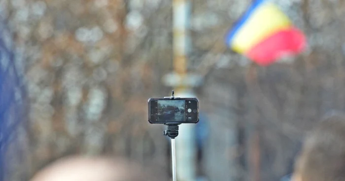 Un român de pe rândurile din spate s-a uitat la parada militară pe ecranul telefonului. El a ridicat dispozitivul peste mulţime cu ajutorul unui selfie-stick. FOTO: Cristian Delcea