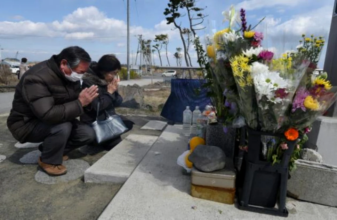 Doi japonezi se roagă la Sendai, la cinci ani după cutremurul, tsunamiul şi accidentul nuclear care au lovit Japonia FOTO AFP