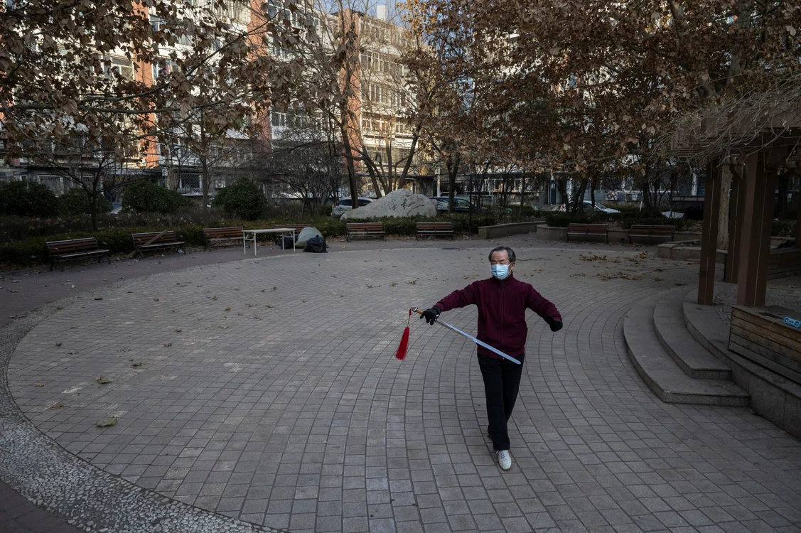 Un bărbat poartă mască în timp ce practică Tai Chi într-un cartier redeschis FOTO Getty Images