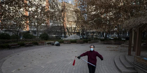 Beijing - China - Un bărbat poartă mască în timp ce practică Tai Chi cu o sabie într-un cartier recent redeschis după carantina COVID-19 FOTO Getty Images