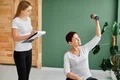 front view elder woman covid recovery doing physical exercises with dumbbell while nurse checks jpg