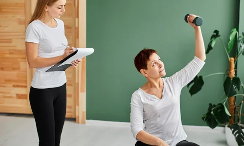 front view elder woman covid recovery doing physical exercises with dumbbell while nurse checks jpg